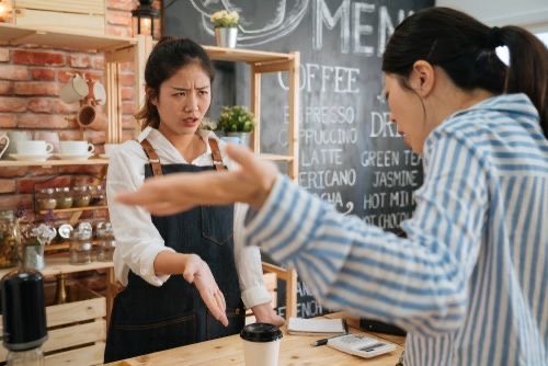 Funcionária de café em discussão acalorada com cliente sobre um pedido